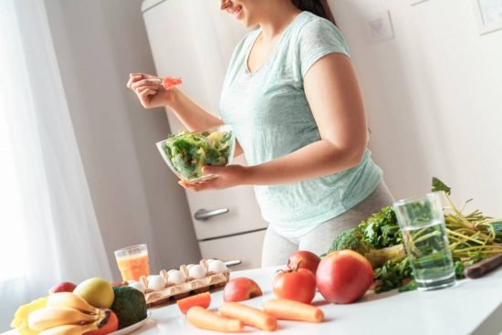 Mujer joven en la cocina dispuesta a comer un almuerzo saludable