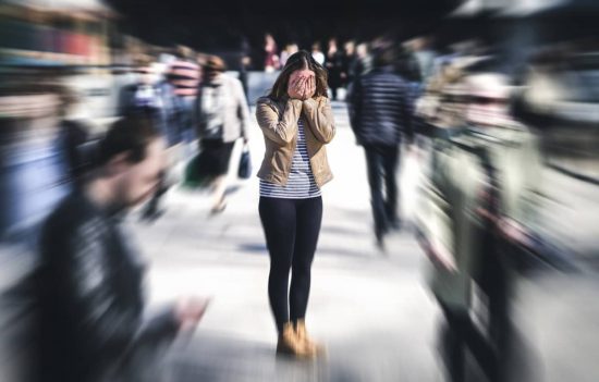 Mujer llevándose las manos a la cara en público