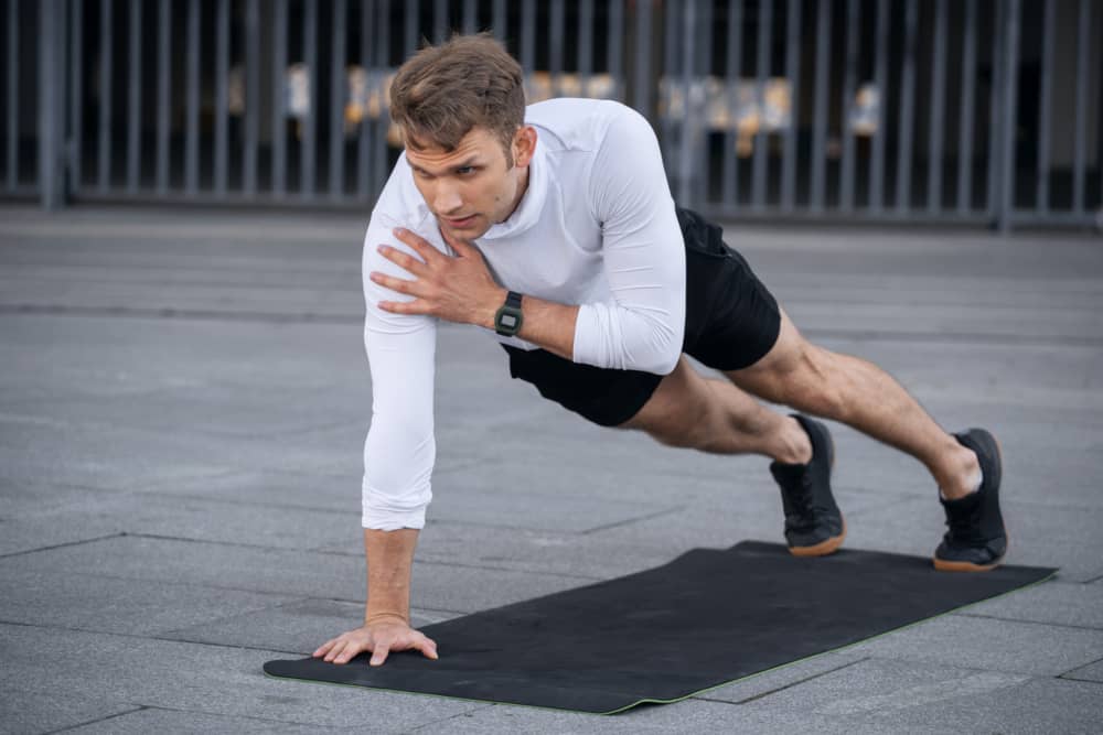 Hombre entrena ejercicios de hombros 