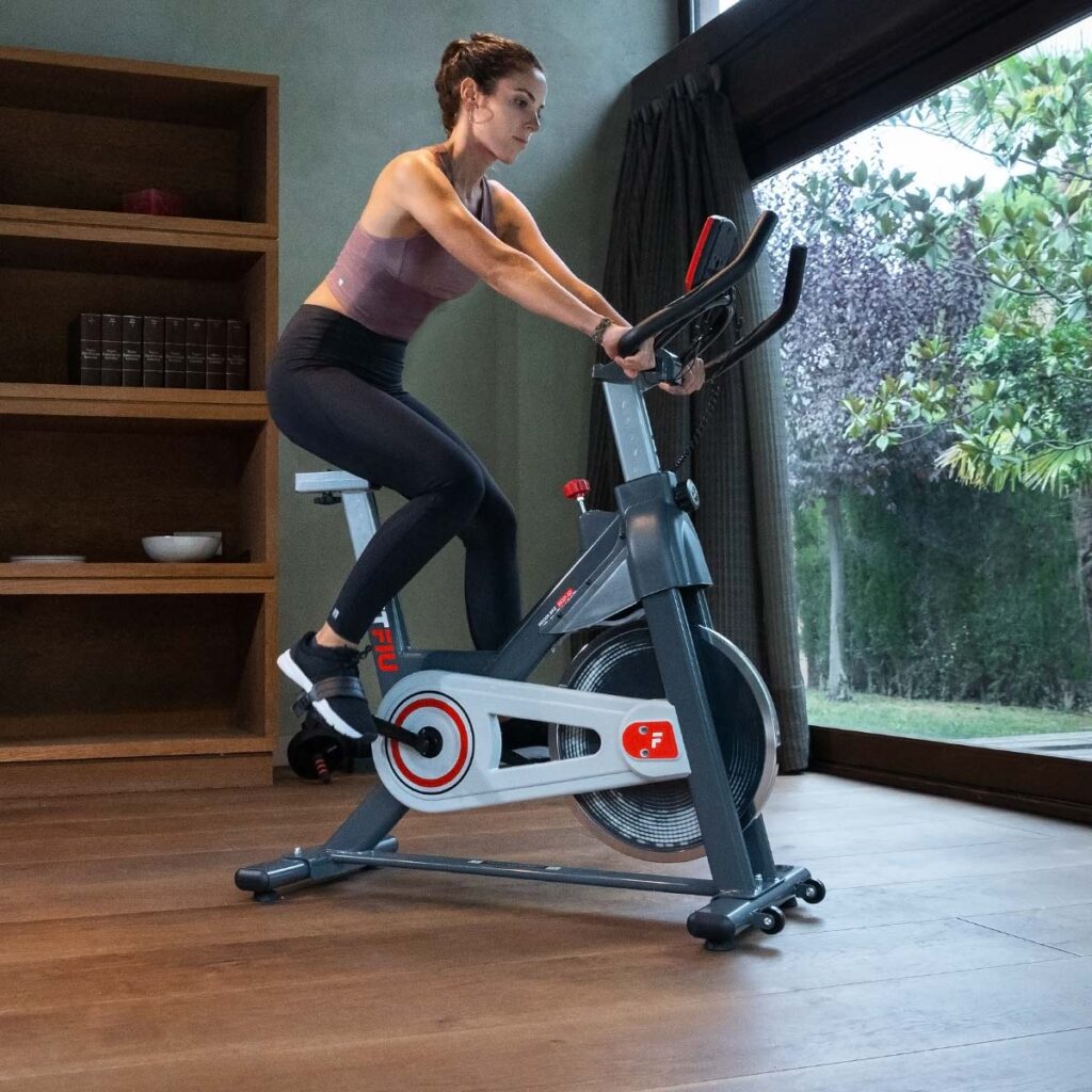 mujer trabajando la salud cardiovascular con bici de spinning