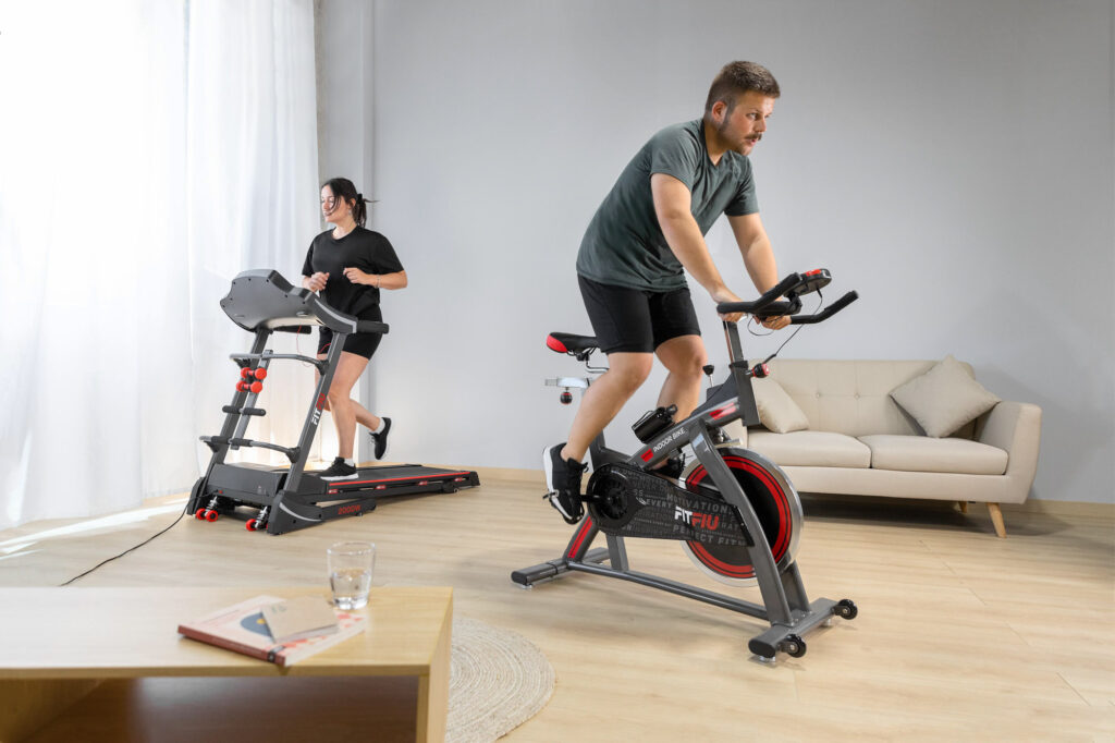 hombre y mujer realizando entrenamiento de cardio con cinta de correr y bicicleta