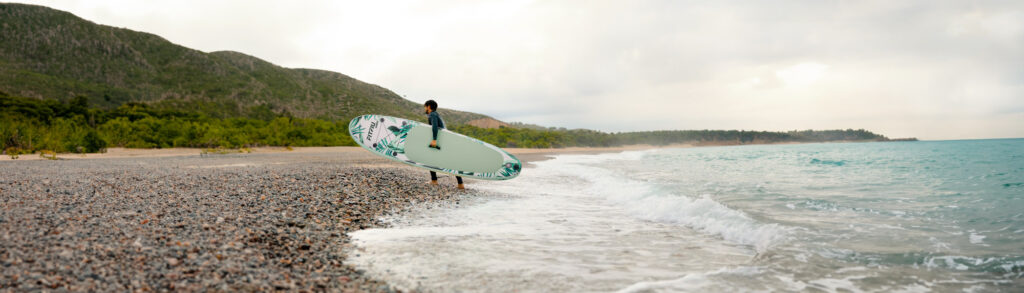 hombre en la playa con paddle surf oahu