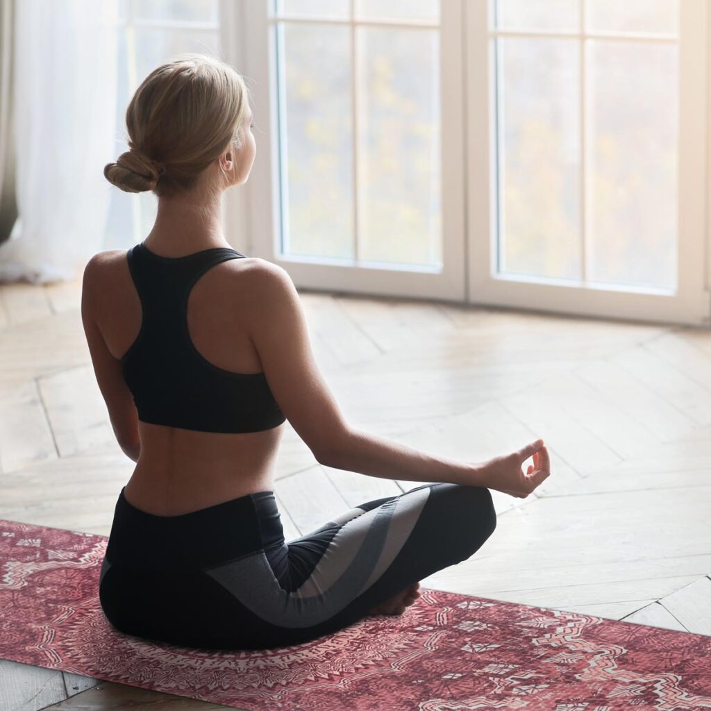 Chica meditando en esterilla de yoga FITFIU